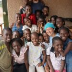 Home Diverse group of people gathered outdoors, smiling and embracing the spirit of togetherness.